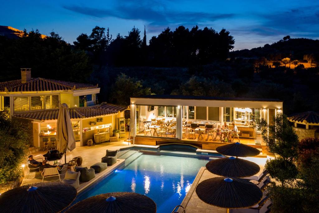 une maison avec une piscine entourée de parasols dans l'établissement Anthemion Suites and Villas, à Nauplie