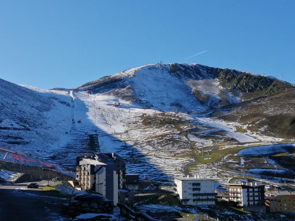 a mountain covered in snow with buildings and buildings at Studio Pla d'Adet in Saint-Lary-Soulan