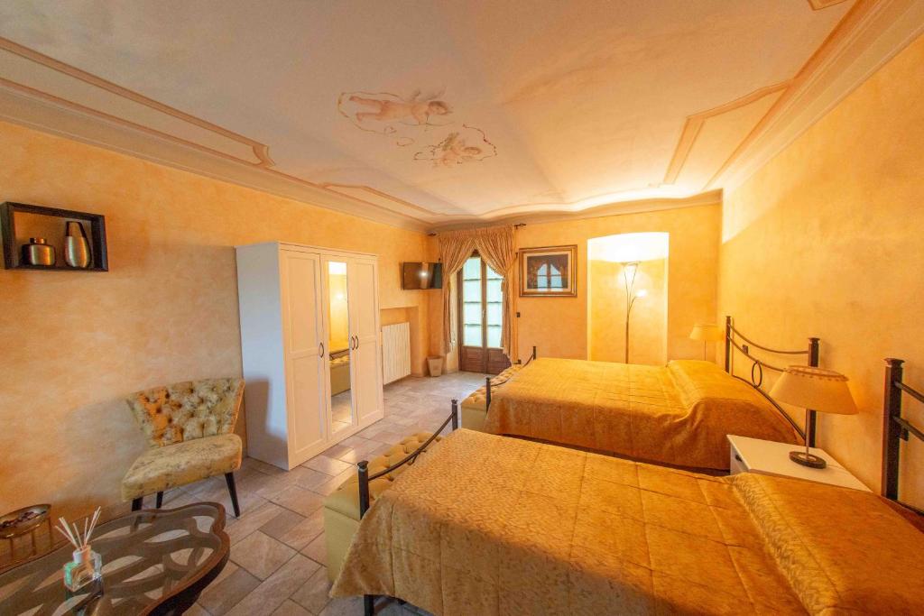 a large bedroom with two beds and a chair at Agriturismo Rihane in Sinio