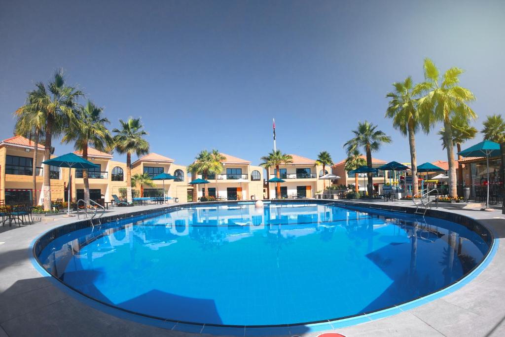 a large pool with blue water in a resort at Palma Beach Resort & Spa in Umm Al Quwain