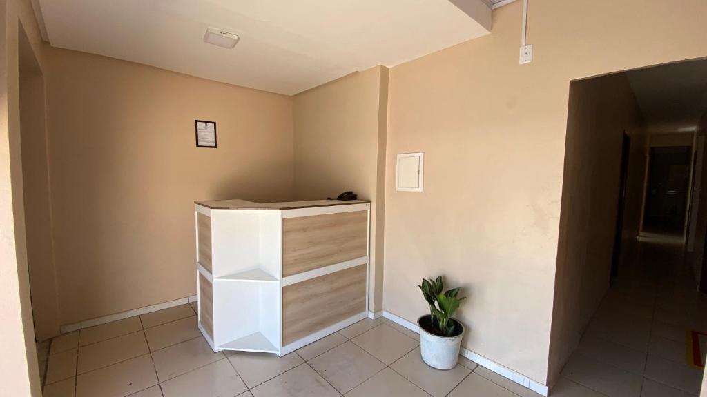 a room with a white cabinet and a potted plant at Hostel Mar in São Luís