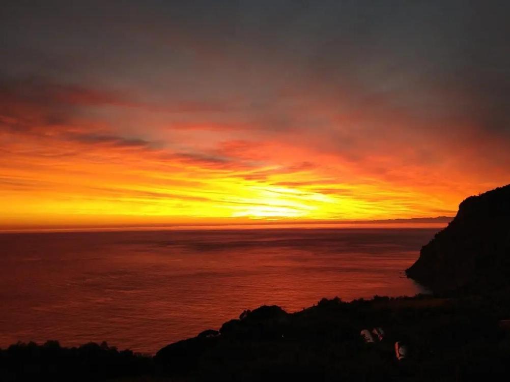 a sunset over the ocean with the sun in the sky at Perla del Levante Hostel in Framura