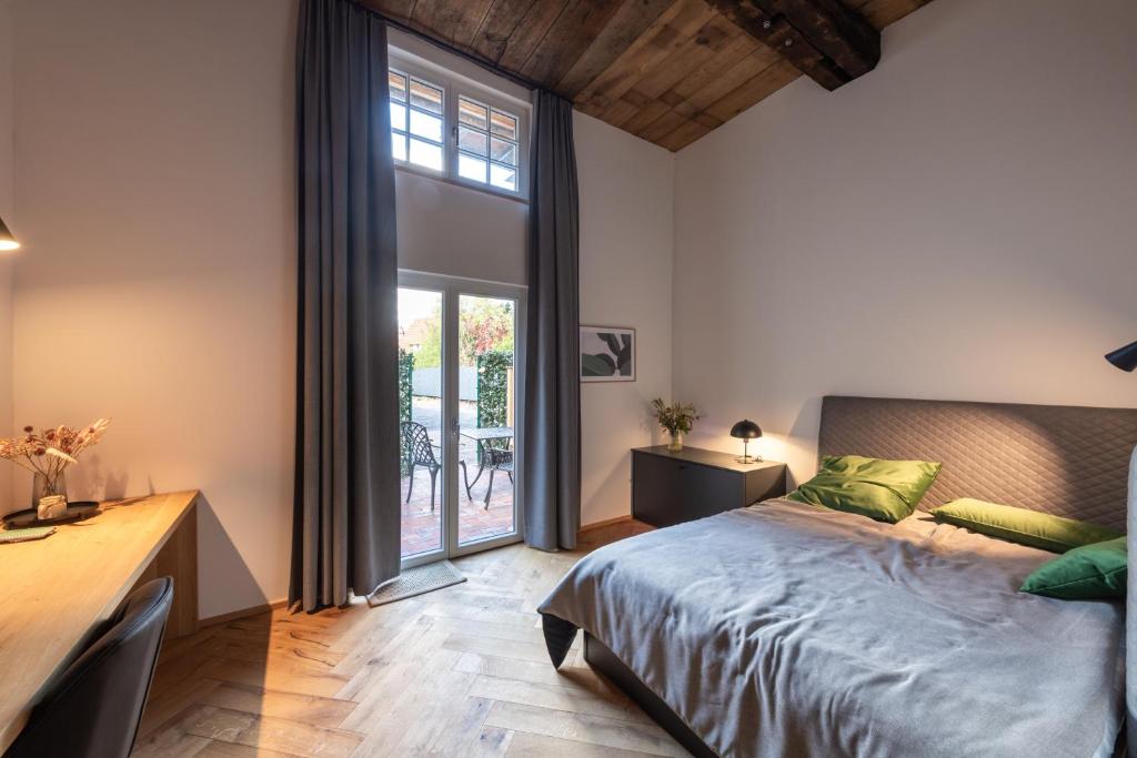 um quarto com uma cama, uma secretária e uma janela em TORhaus Appartments Sendenhorst em Sendenhorst