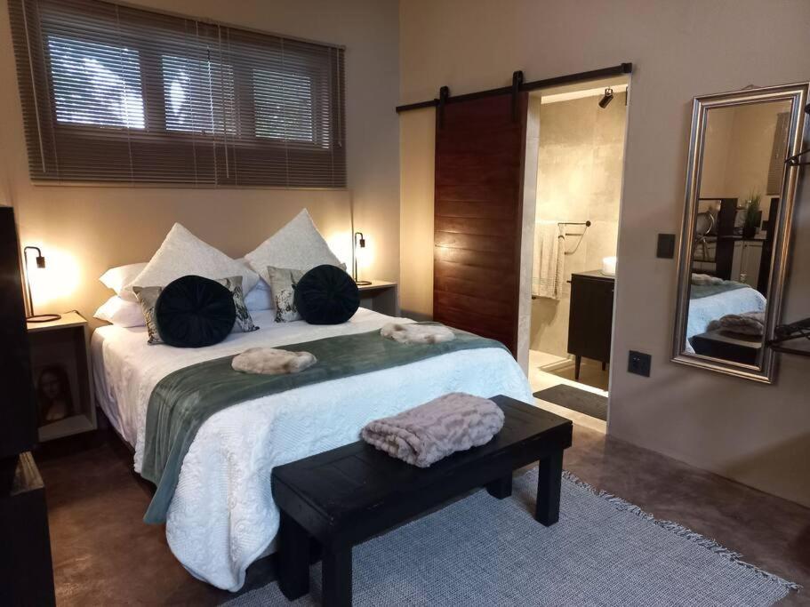 1 dormitorio con 1 cama grande y espejo en Stacey's Cornerstone Studio Apartment, en Hillcrest
