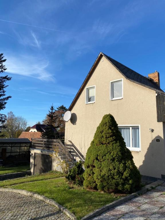 ein Haus mit einem großen Busch davor in der Unterkunft Am Fuße zur Napoleonschanze in Hohnstein