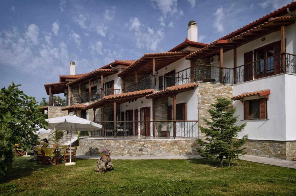 a large house with a dog sitting in front of it at Hotel Ainareti in Kala Nera