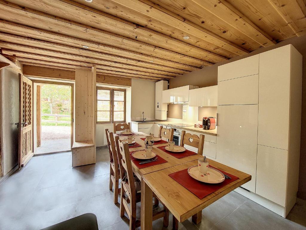 jadalnia z drewnianym stołem i kuchnią w obiekcie CHEZ HENRI Appartement 4 a 6 personnes proche remontees mecaniques w mieście Saint-Jean-dʼAulps