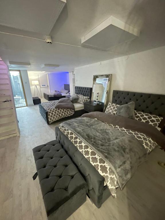 a large bedroom with a bed and a mirror at Cwtch Cardiff Bay in Cardiff