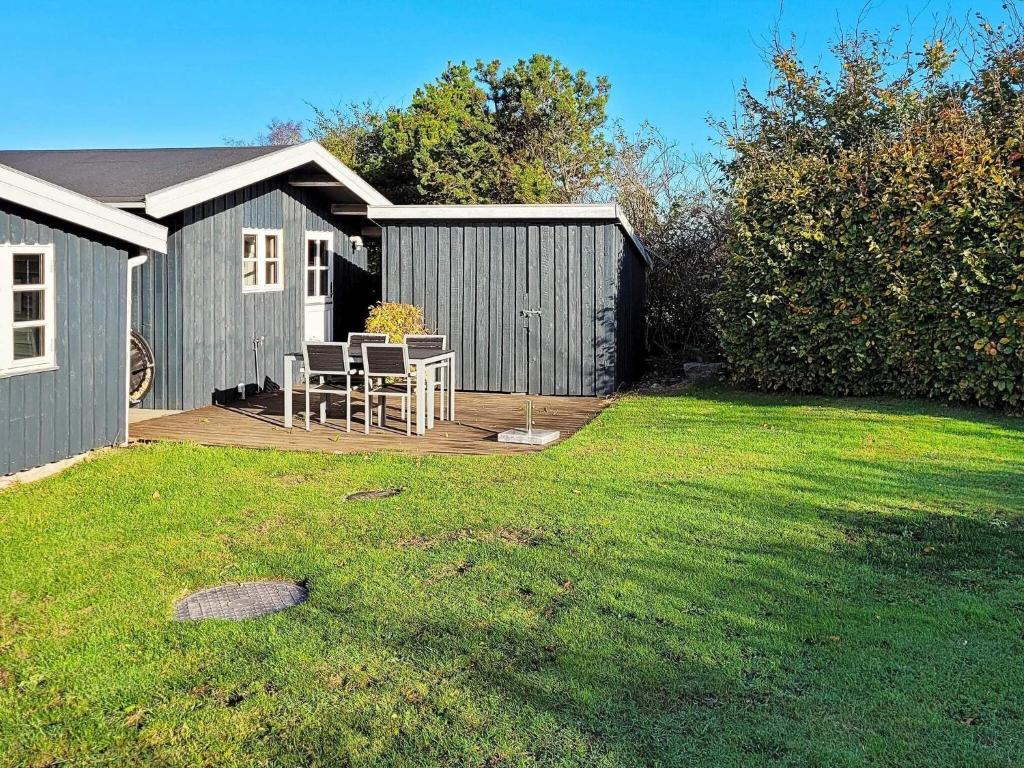 a backyard with a table and chairs on a deck at 6 person holiday home in Glesborg in Glesborg