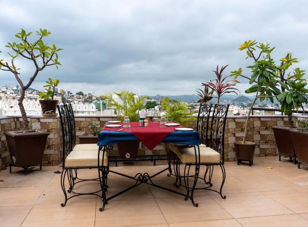 a table and chairs on a balcony with a view at Baba Palace - A Heritage Hotel, Udaipur in Udaipur