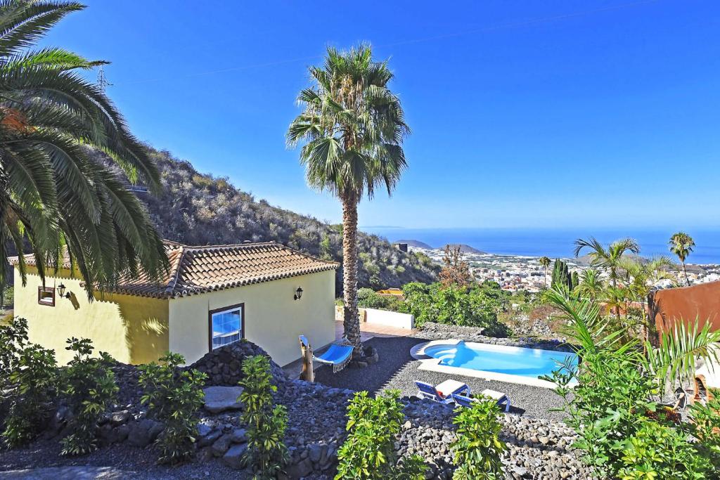 a house with a palm tree and a swimming pool at Casa Rincón Palmero in El Paso