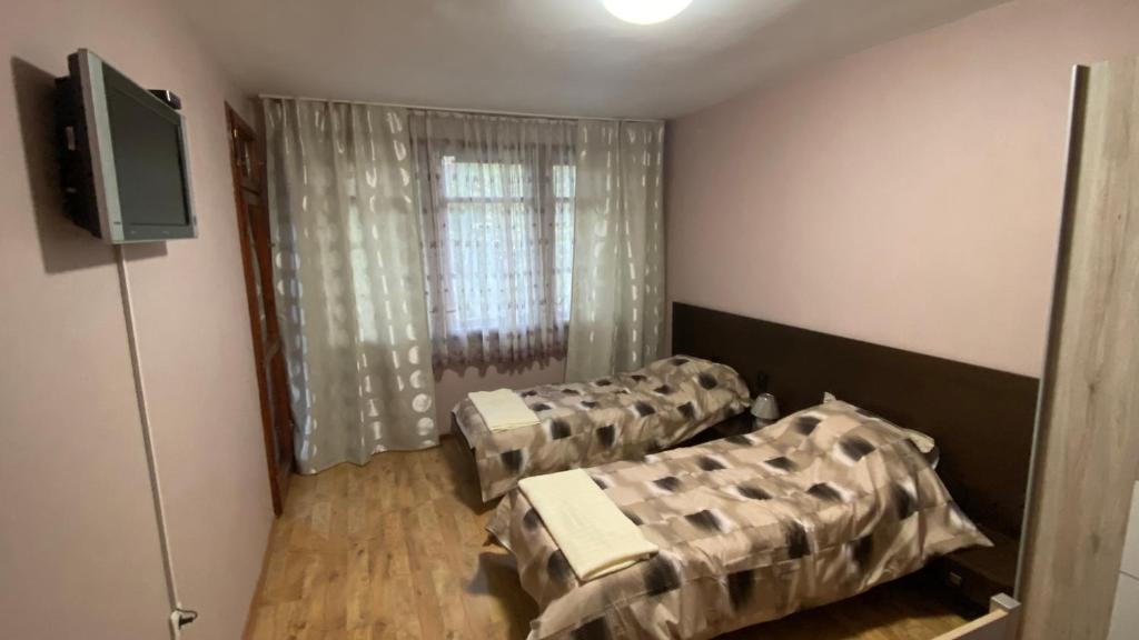 a room with two beds and a flat screen tv at J&Z Rooms in Burgas