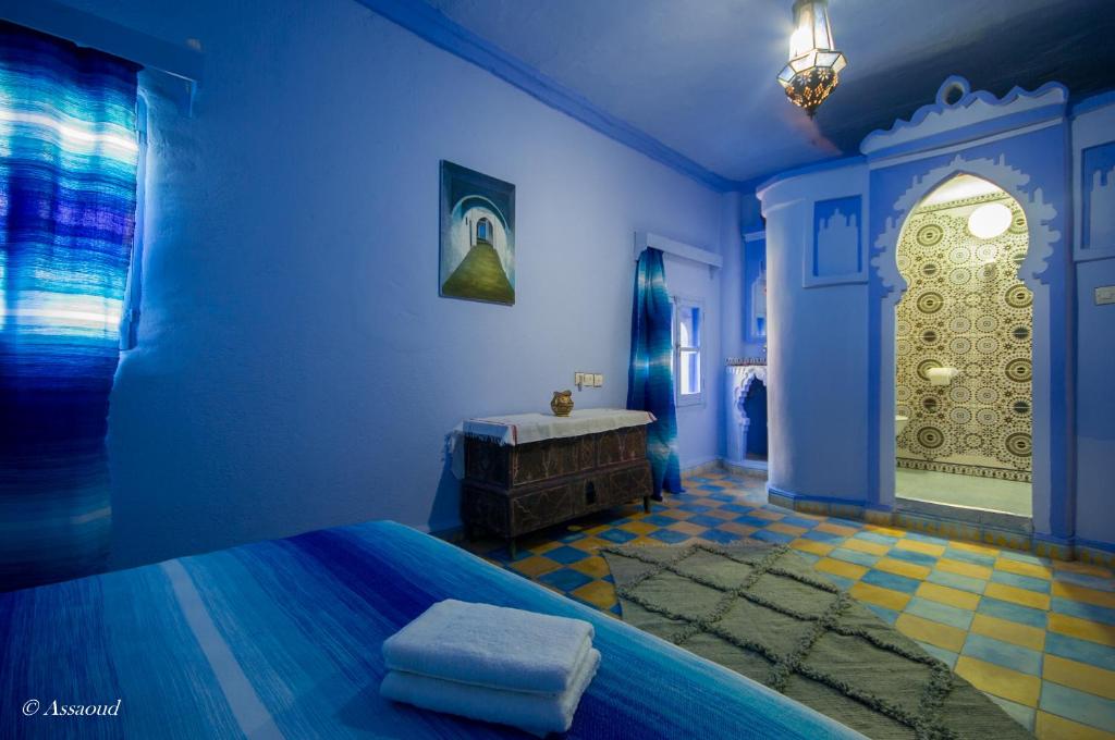 a blue room with a bed and a bath tub at Dar El Fanne in Chefchaouen