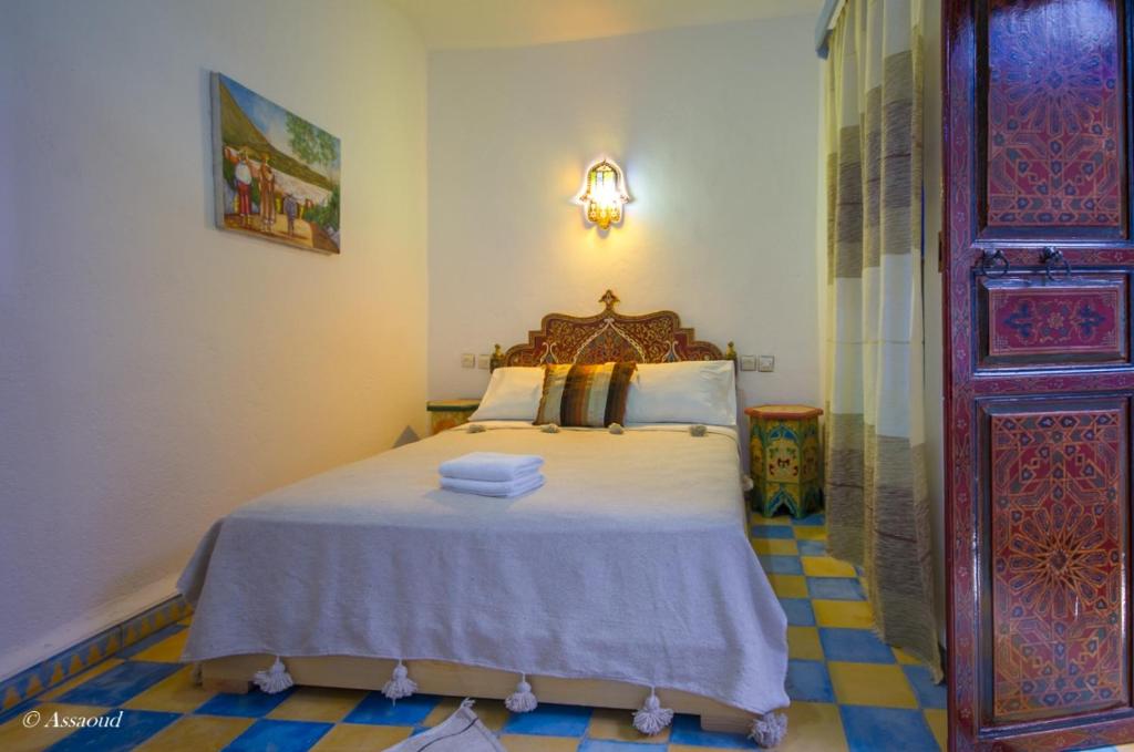 a bedroom with a bed with towels on it at Dar El Fanne in Chefchaouen