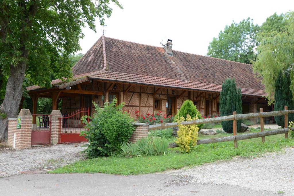 a wooden house with a fence in front of it at Le Clos du Rossignol in Le Tartre