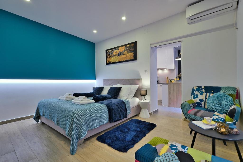 a bedroom with a bed and a blue wall at Aurea City Center Apartment Zagreb in Zagreb