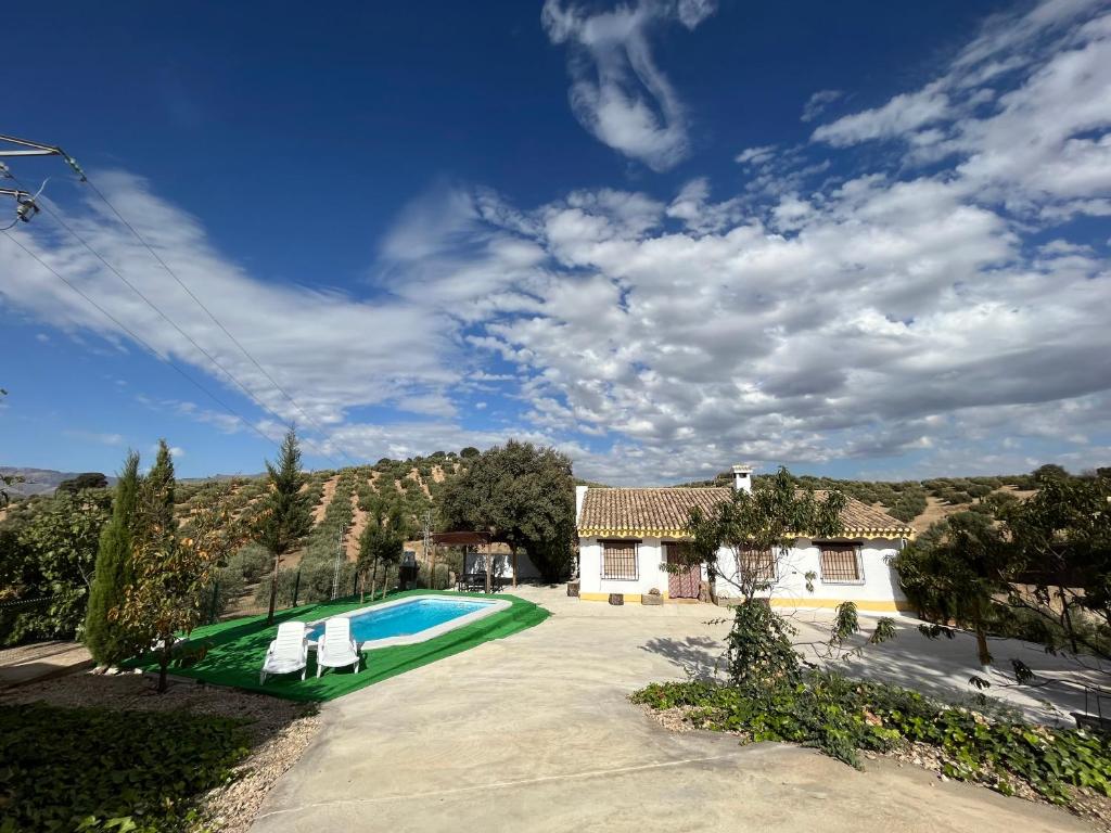 a villa with a swimming pool and a house at Cortijo El Nevazo in Fuentes de Cesna
