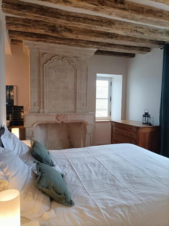 a bedroom with a large white bed and a window at Gîte Apolise in Saint-Rémy-la-Varenne