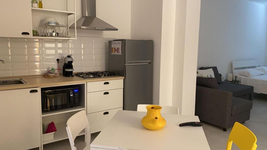 a kitchen with a table with a yellow vase on it at Carolina Apartments - Monolocale in Capo dʼOrlando