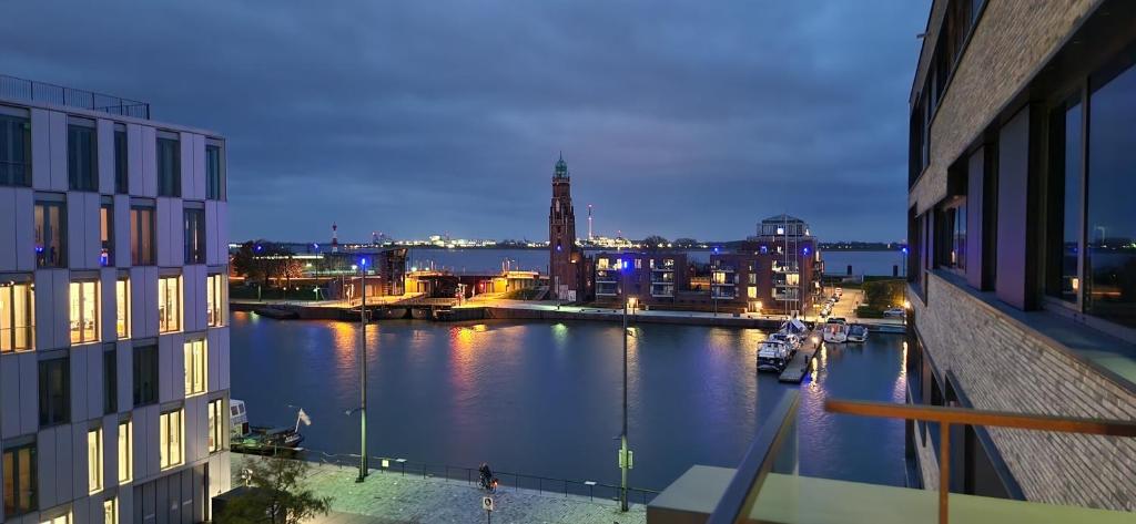 Blick auf einen Fluss in der Nacht von einem Gebäude aus in der Unterkunft Homey Apartments Harbor Suite - Parking Two Bathrooms Netflix Sea view in Bremerhaven