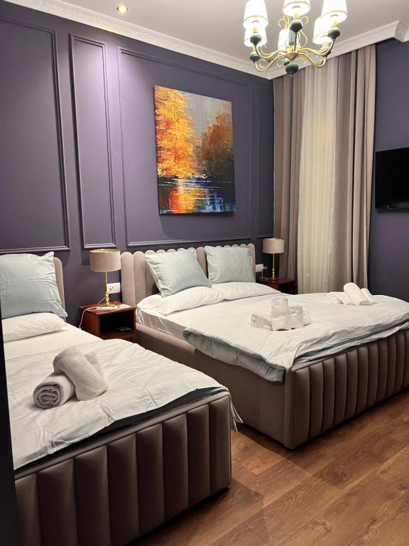 Duas camas num quarto com um quadro na parede em Amo's Hotel em Shkodër