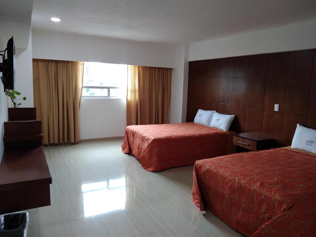 ein Hotelzimmer mit 2 Betten und einem Fenster in der Unterkunft Hotel RRU Puebla in Puebla