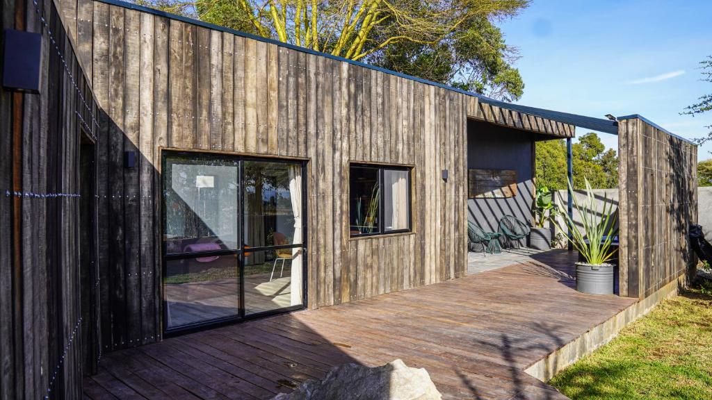 une maison en bois avec des portes en verre et une terrasse dans l'établissement The Croft, à Nakuru