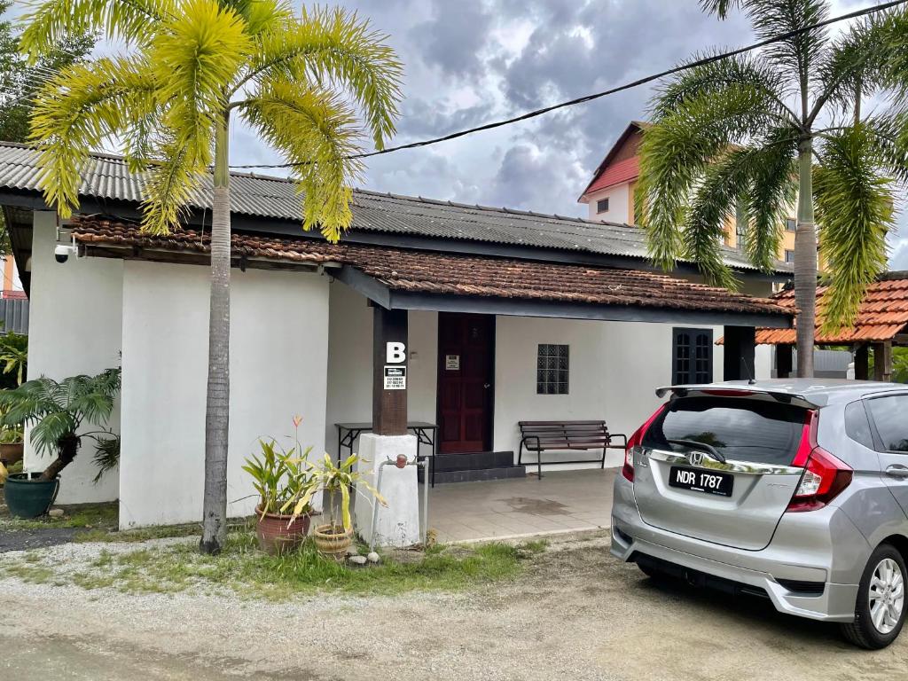 um carro estacionado em frente a uma casa em Hj Hassan Guest House Bungalow B em Kuala Terengganu