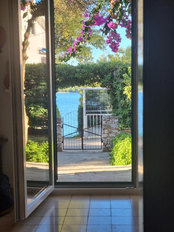 uma porta aberta com vista para um portão em Apartment Bepo em Seget Vranjica