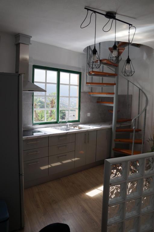 uma cozinha com uma escada, um lavatório e uma escada. em Casa Teide em La Orotava