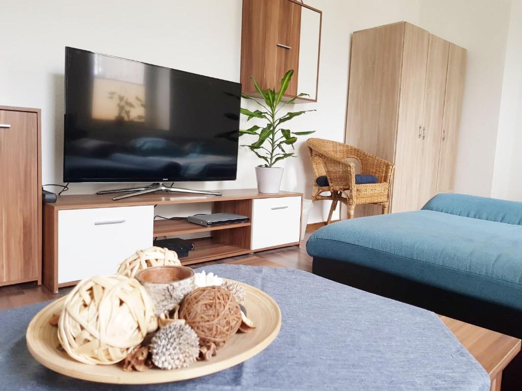 a living room with a tv and a table with a basket at Haus Ajax in Anklam