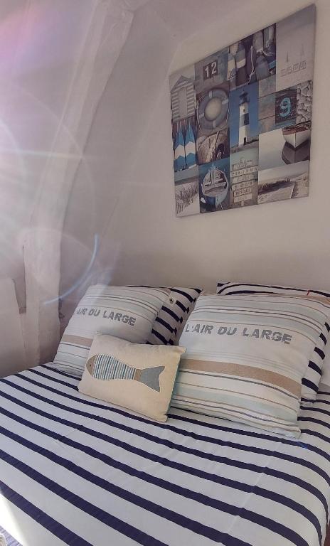 une chambre avec un lit à rayures bleues et blanches dans l'établissement La petite Dieppoise 3 étoiles meublé de tourisme Entre plage et port, à Dieppe