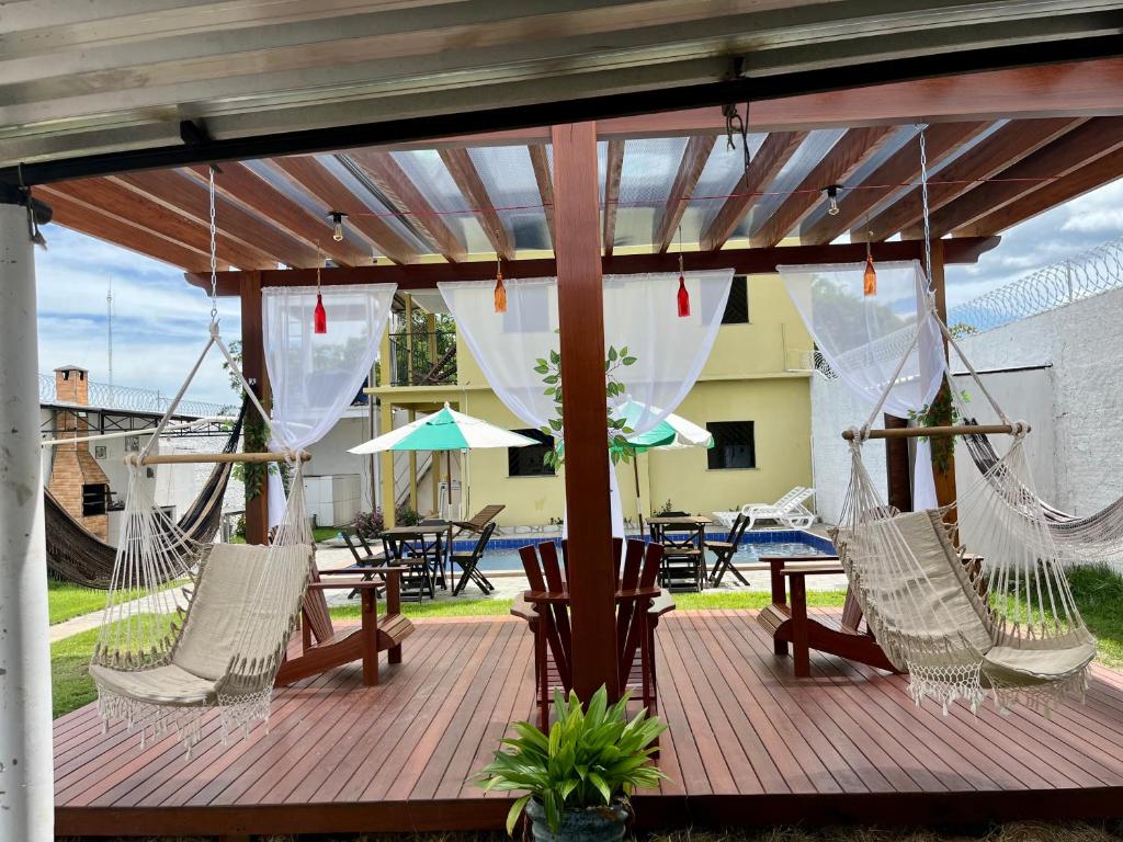 a deck with hammocks and a table and chairs at Casa Boto Tucuxi 1 in Novo Airão