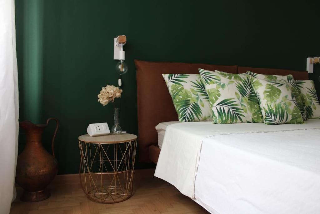a bedroom with a white bed and a green wall at Casa Sivori sul lago di Garda con ampio giardino in Desenzano del Garda