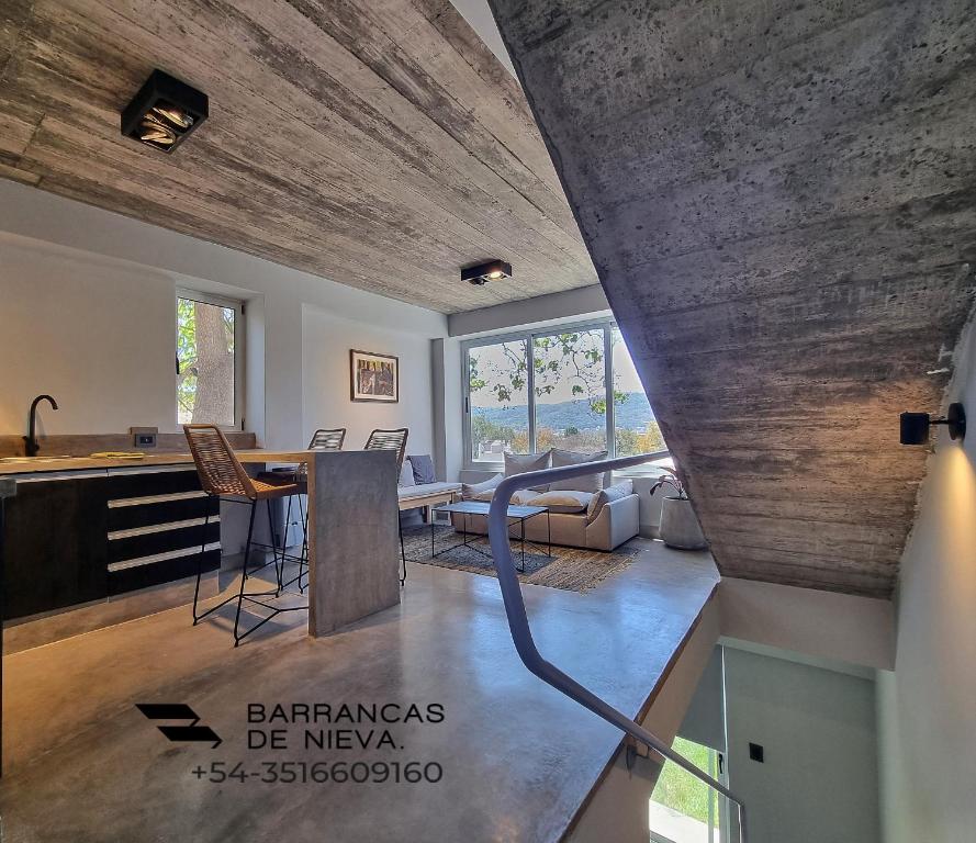 a kitchen and living room with a wooden ceiling at Barrancas de Nieva B03 in San Salvador de Jujuy