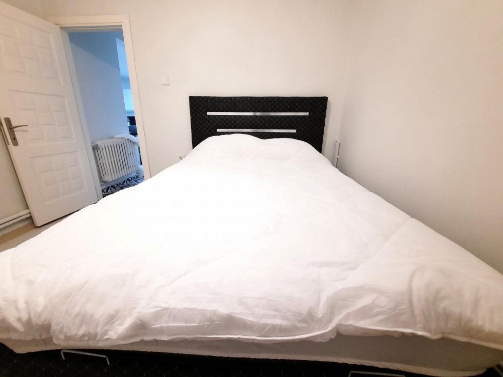 uma grande cama branca com uma cabeceira preta num quarto em Garanti em Istambul