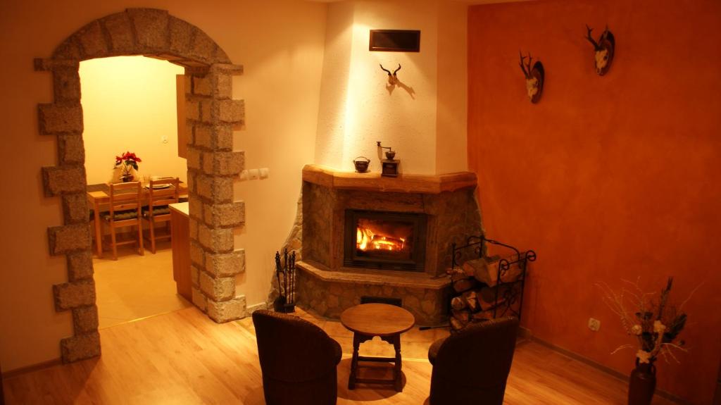 a living room with a fireplace and a table and chairs at Pod Chybotkiem in Szklarska Poręba