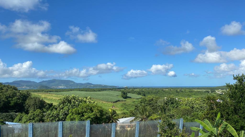Blick auf die Hügel hinter einem Zaun in der Unterkunft La Villa Davy in Ducos