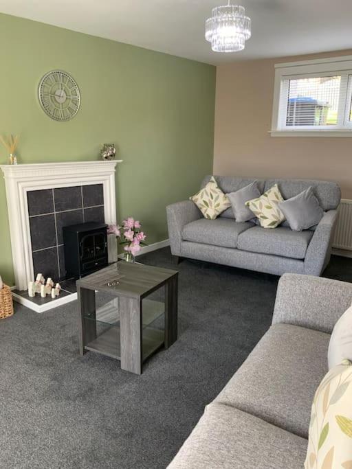 sala de estar con sofá y chimenea en Home from home, 3 bedroom house in Hawick, en Hawick