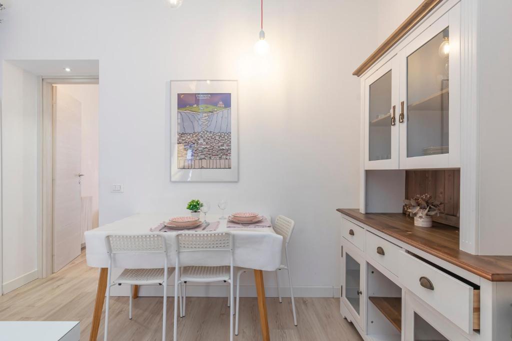 uma cozinha com uma mesa branca e cadeiras brancas em [New flat] Crocetta 2 em Milão