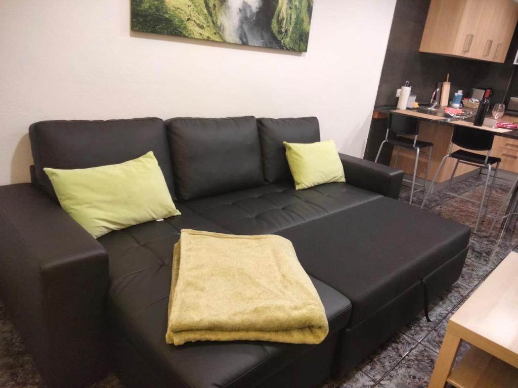 un divano nero con cuscini gialli in soggiorno di Amaba TENERIFE a La Guancha