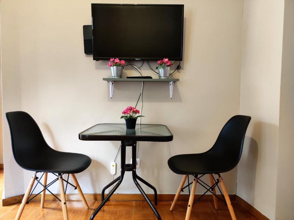 ポルトにあるFullHouse Portoの椅子2脚、テーブル(壁にテレビ付)