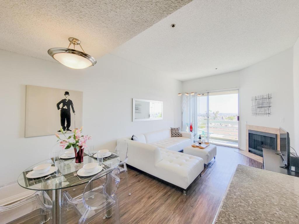 een woonkamer met een witte bank en een tafel bij Hollywood Take 2! 1-Bedroom with Balcony & VIEWS! in Los Angeles
