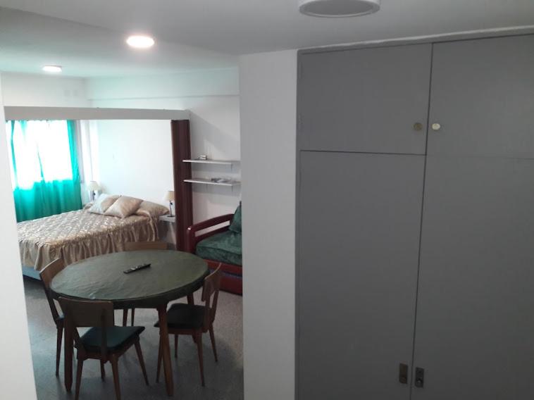 ein Zimmer mit einem Tisch und ein Schlafzimmer mit einem Bett in der Unterkunft Dpto Olavarria in Mar del Plata