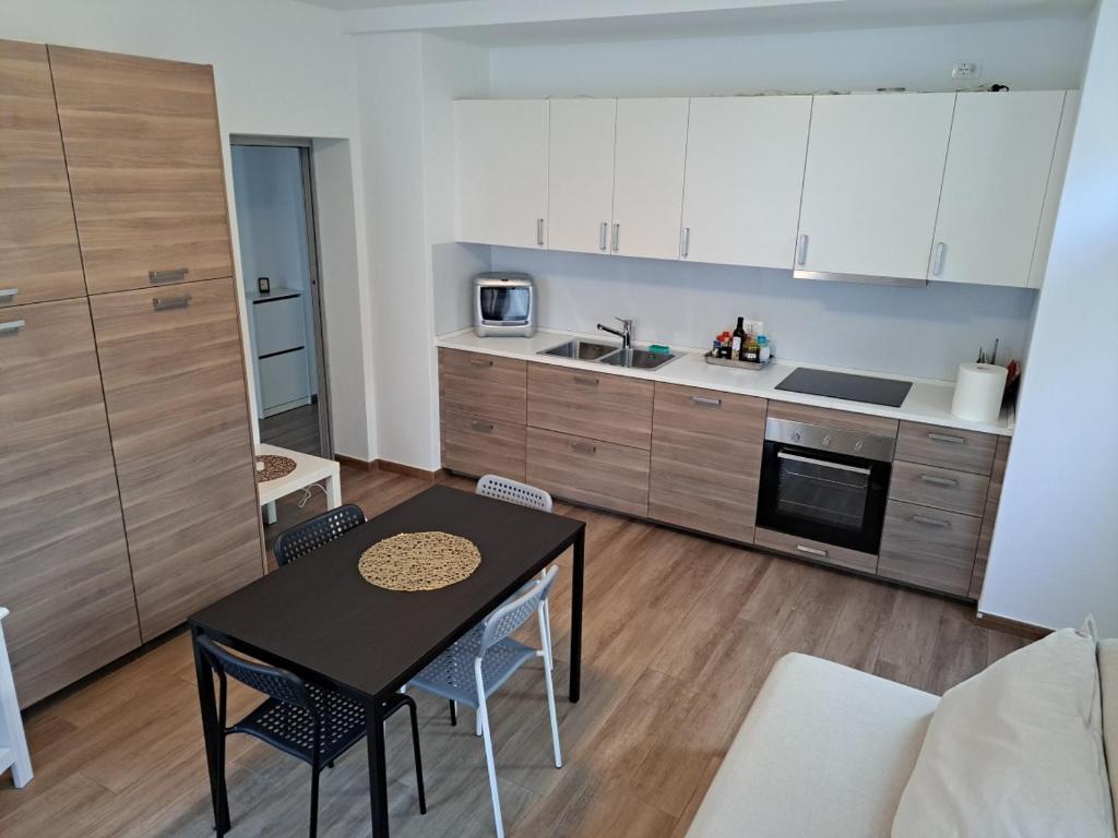 VILLA ESTER -Residenze dolomitiche- في بييفي دي كادوري: مطبخ وغرفة معيشة مع طاولة وكراسي