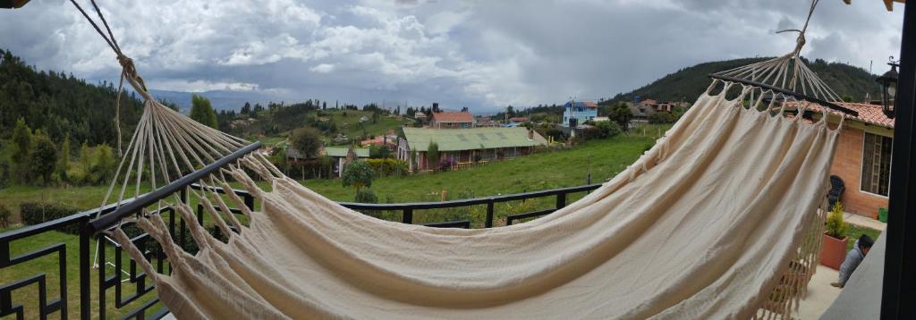 a hammock hanging from a balcony with a view at Refugio MALUAN.. Cabaña Villa Nepo in Paipa