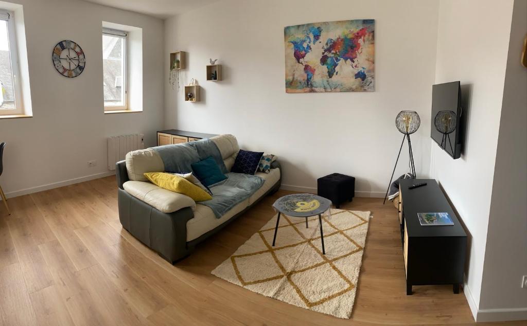 sala de estar con sofá y mesa en Gîte mont-blan, en Pontorson