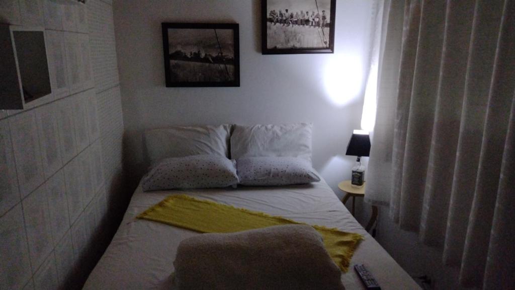 a small bedroom with a bed with two pillows at Hostel Convention Expo SP in Sao Paulo