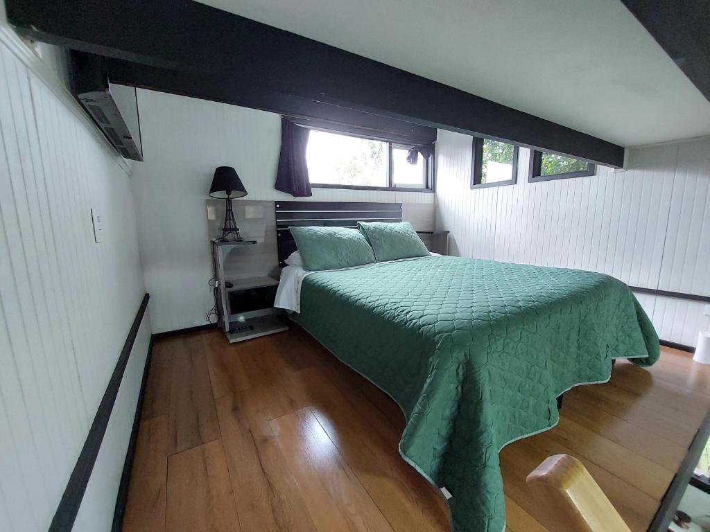 1 dormitorio con 1 cama con edredón verde en Loft a pasos del centro con estacionamiento, en Los Ángeles