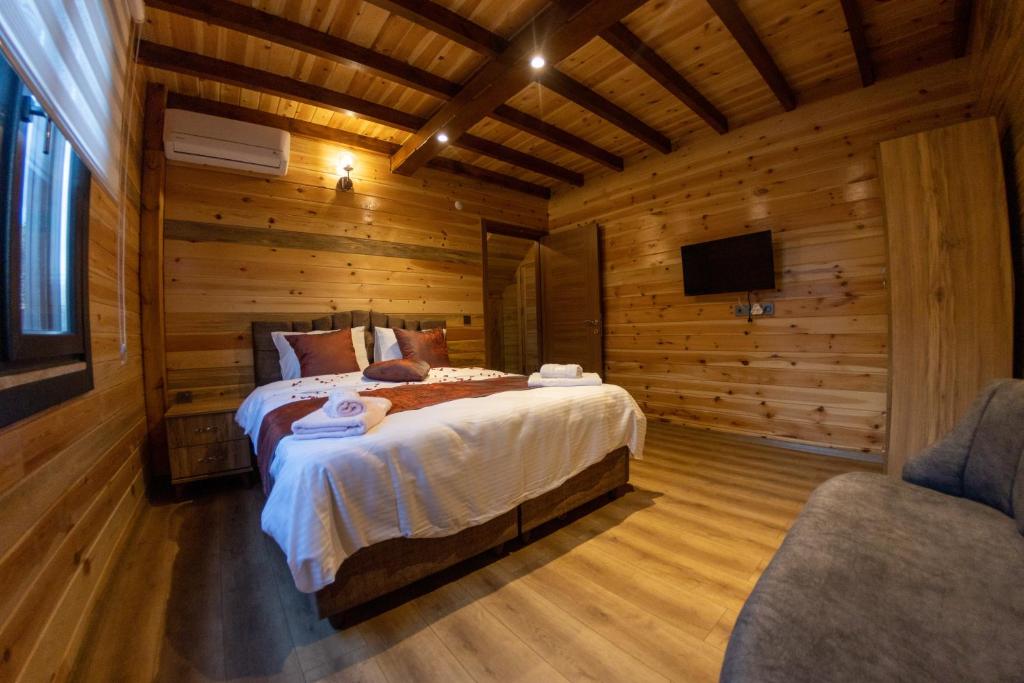a bedroom with a bed in a wooden room at sapancafamilyresort Isıtmalı jakuzili havuzu ile Ahşap aile villası in Kartepe